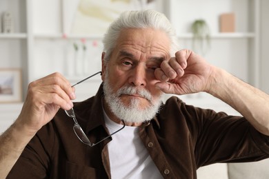 Photo of Senior man suffering from eyestrain at home