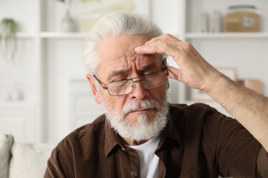 Photo of Senior man suffering from eyestrain at home