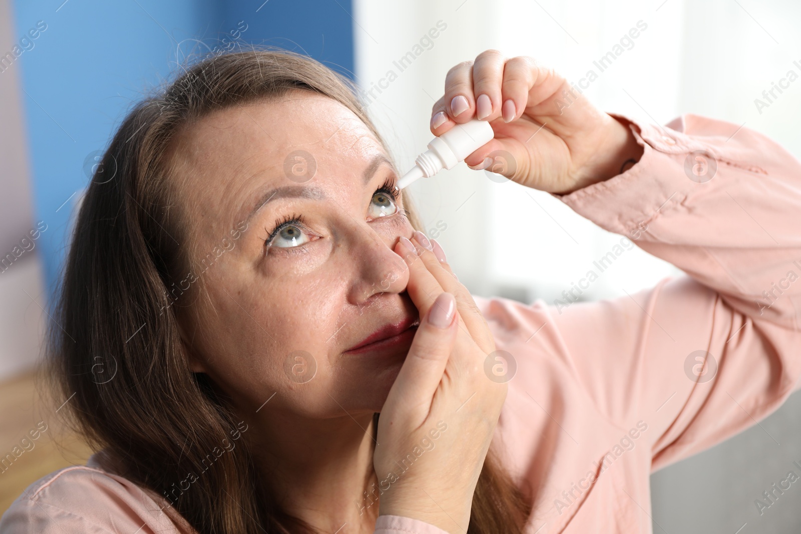 Woman with vision problem applying eye drops at home Photo of Woman with vision problem applying eye drops at home