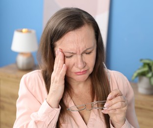 Photo of Woman with glasses suffering from eyestrain at home