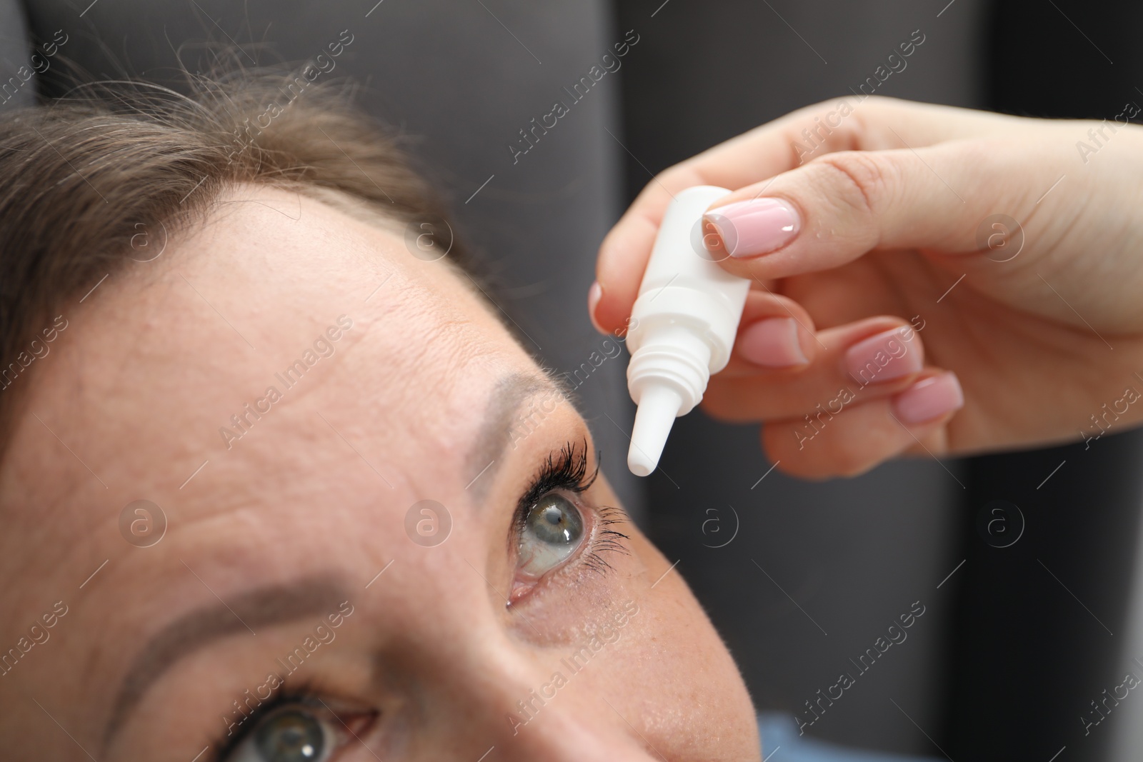 Daughter dripping medication into mother's eye at home, closeup Photo of Daughter dripping medication into mother's eye at home, closeup