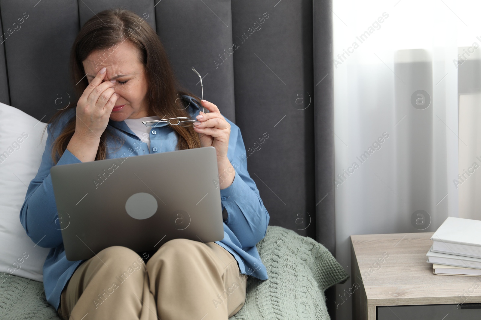 Woman with vision problem using laptop on bed at home Photo of Woman with vision problem using laptop on bed at home