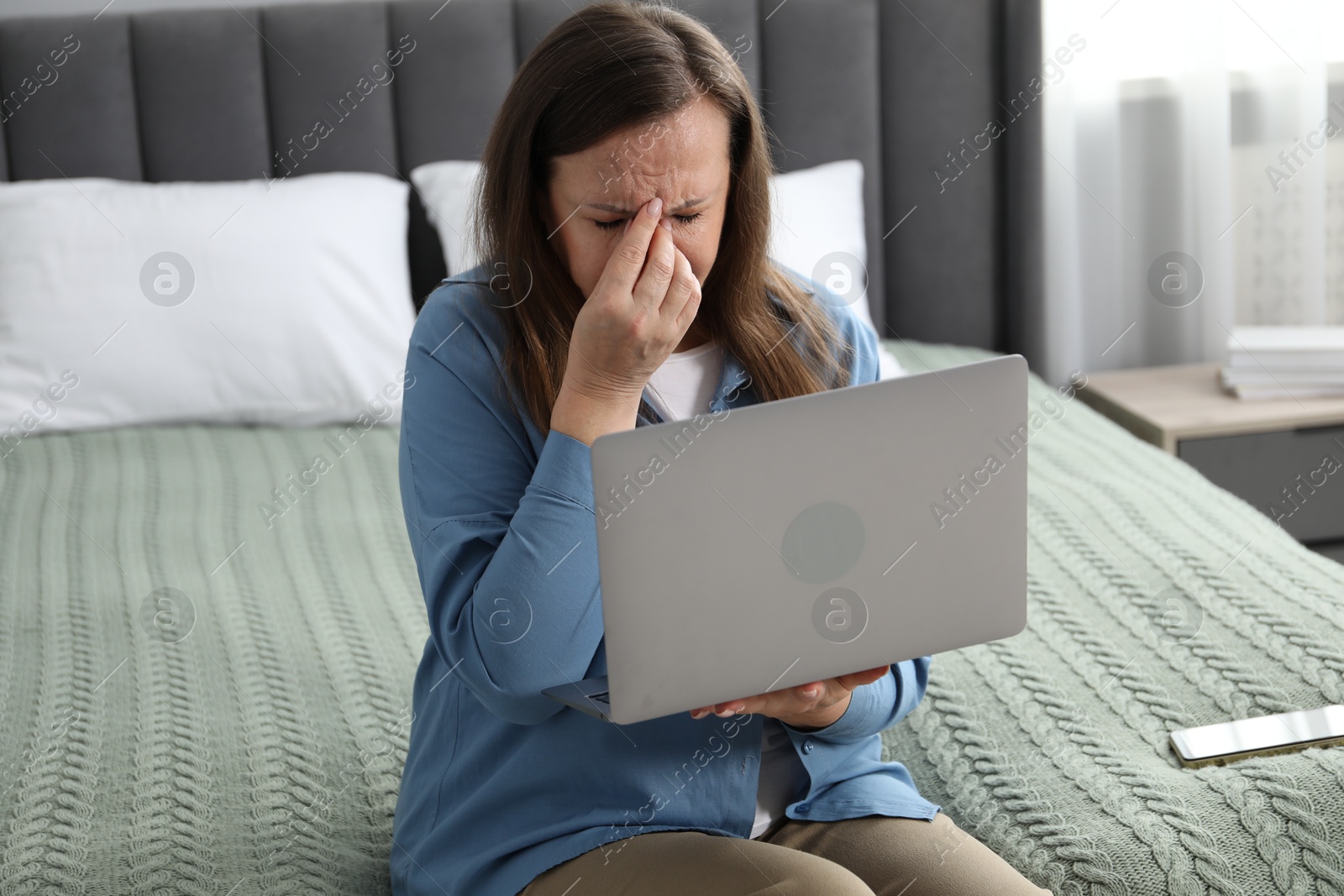 Woman with vision problem using laptop on bed at home Photo of Woman with vision problem using laptop on bed at home