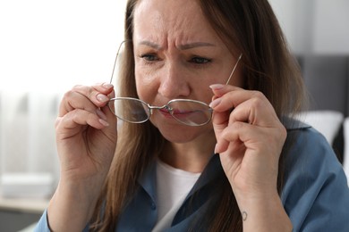 Photo of Woman with vision problem wearing glasses at home