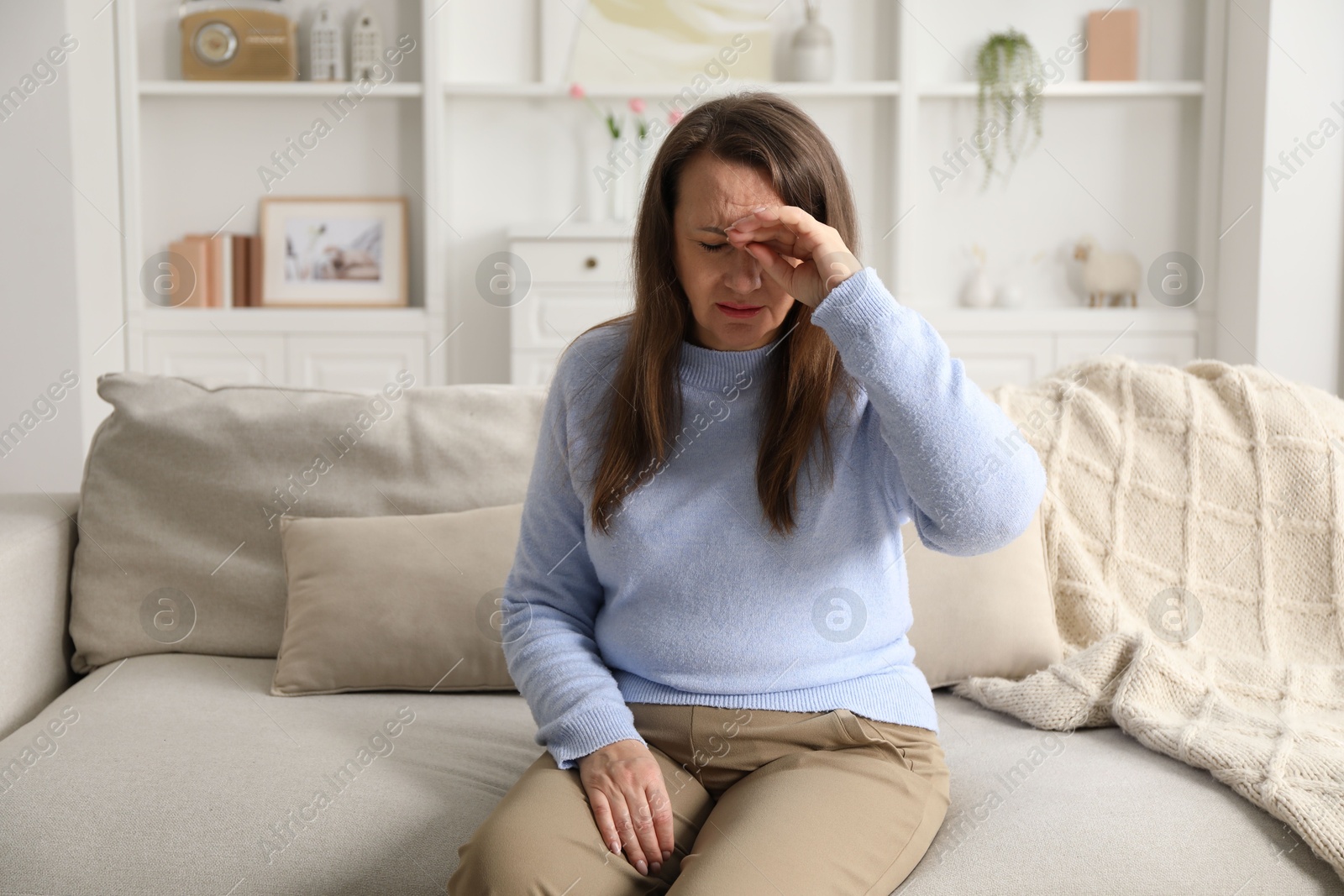 Woman suffering from eyestrain on sofa at home Photo of Woman suffering from eyestrain on sofa at home