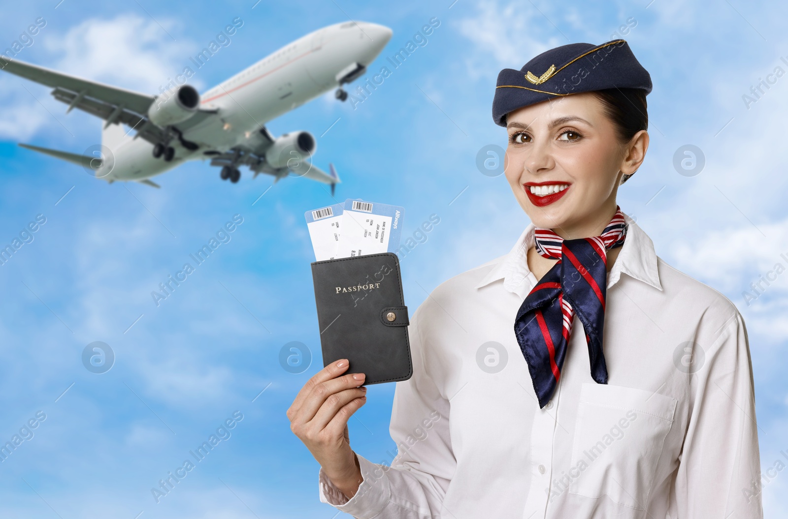 Smiling stewardess holding passport against blue sky with clouds and plane Image of Smiling stewardess holding passport against blue sky with clouds and plane