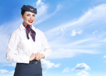 Image of Smiling stewardess against blue sky with clouds