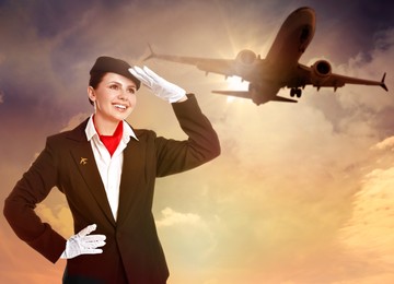 Image of Smiling stewardess against sunset sky with plane and clouds