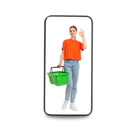Image of Happy woman with shopping basket walking out of mobile phone on white background. Online ordering