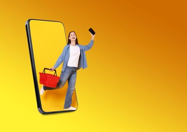 Image of Happy woman with shopping basket walking out of mobile phone on orange gradient background. Online ordering