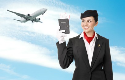 Image of Smiling stewardess holding passport against blue sky with plane and clouds