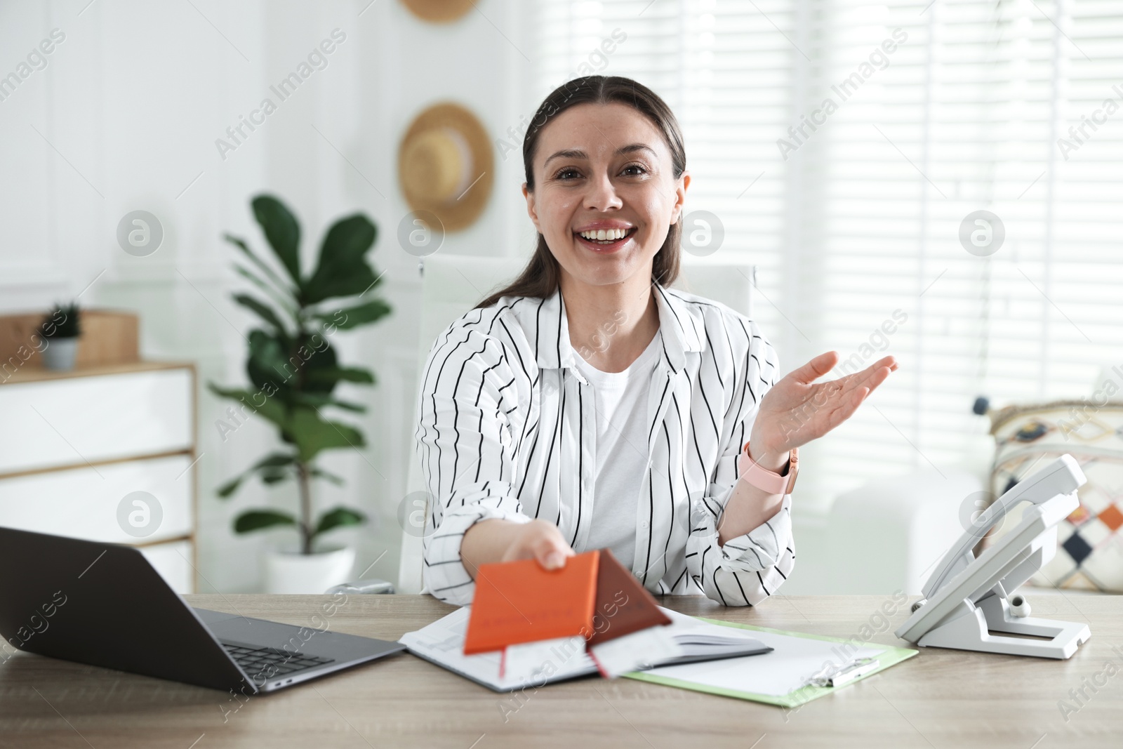 Travel agent with passports and tickets at wooden table in office Photo of Travel agent with passports and tickets at wooden table in office