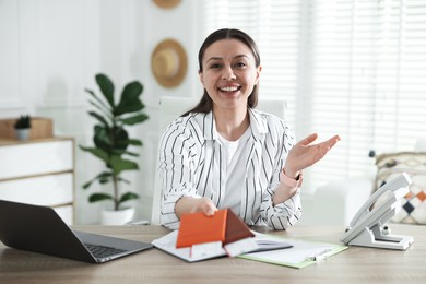 Photo of Travel agent with passports and tickets at wooden table in office