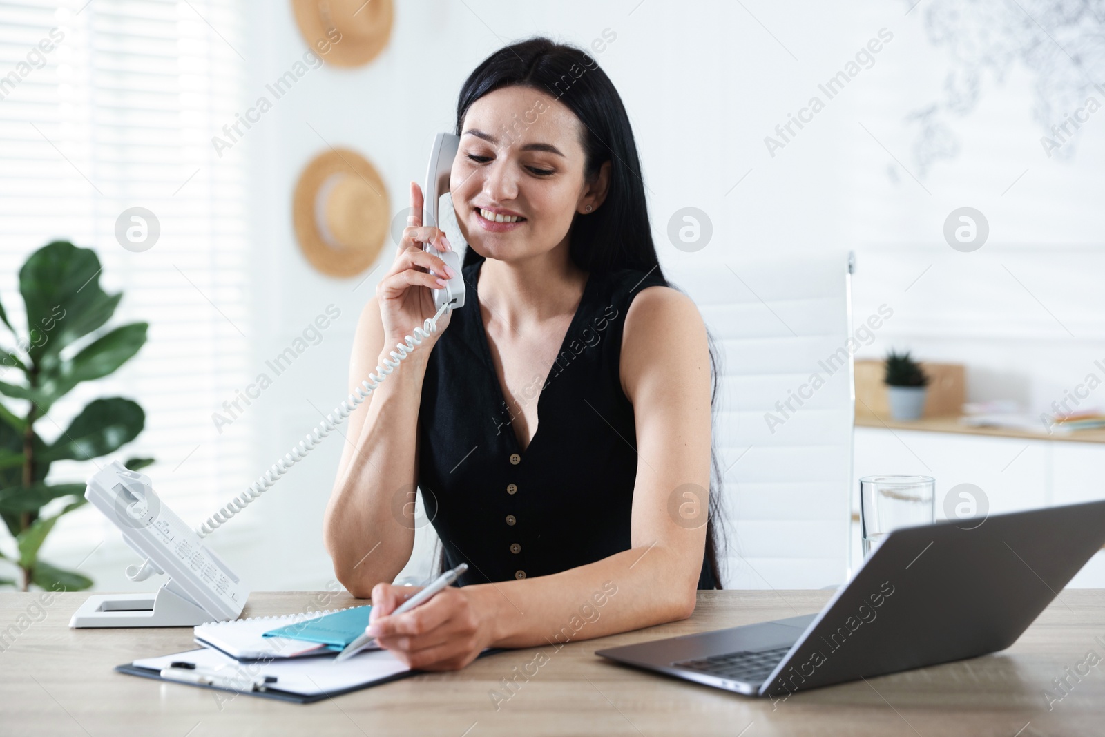 Travel agent working at wooden table in office Photo of Travel agent working at wooden table in office