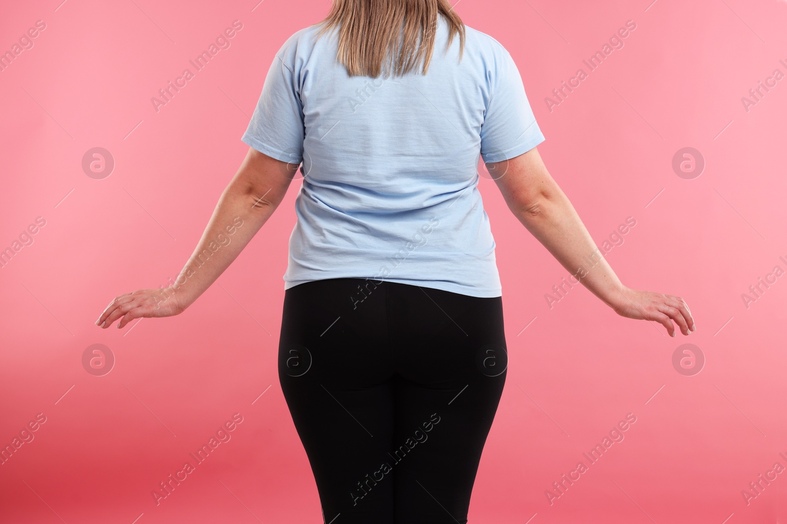Weight loss. Plus size woman on pink background, closeup Photo of Weight loss. Plus size woman on pink background, closeup