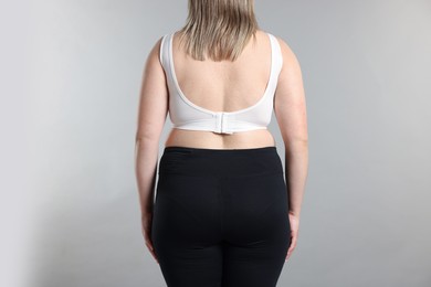 Photo of Weight loss. Plus size woman on gray background, closeup