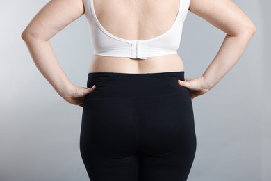 Photo of Weight loss. Plus size woman on gray background, closeup
