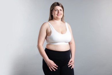 Photo of Weight loss. Plus size woman on gray background
