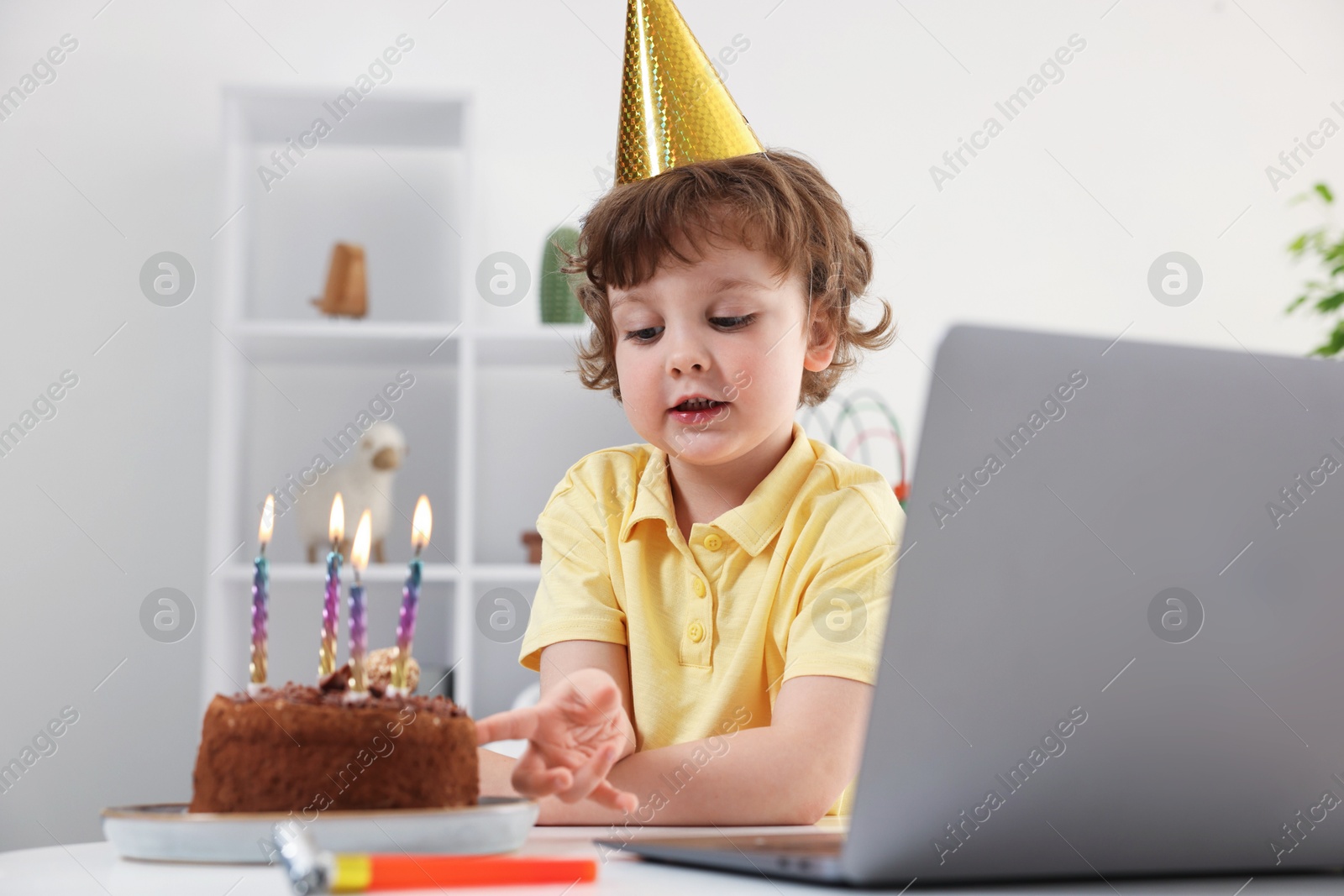Birthday celebration. Little boy with cake having video call via laptop at table indoors Photo of Birthday celebration. Little boy with cake having video call via laptop at table indoors