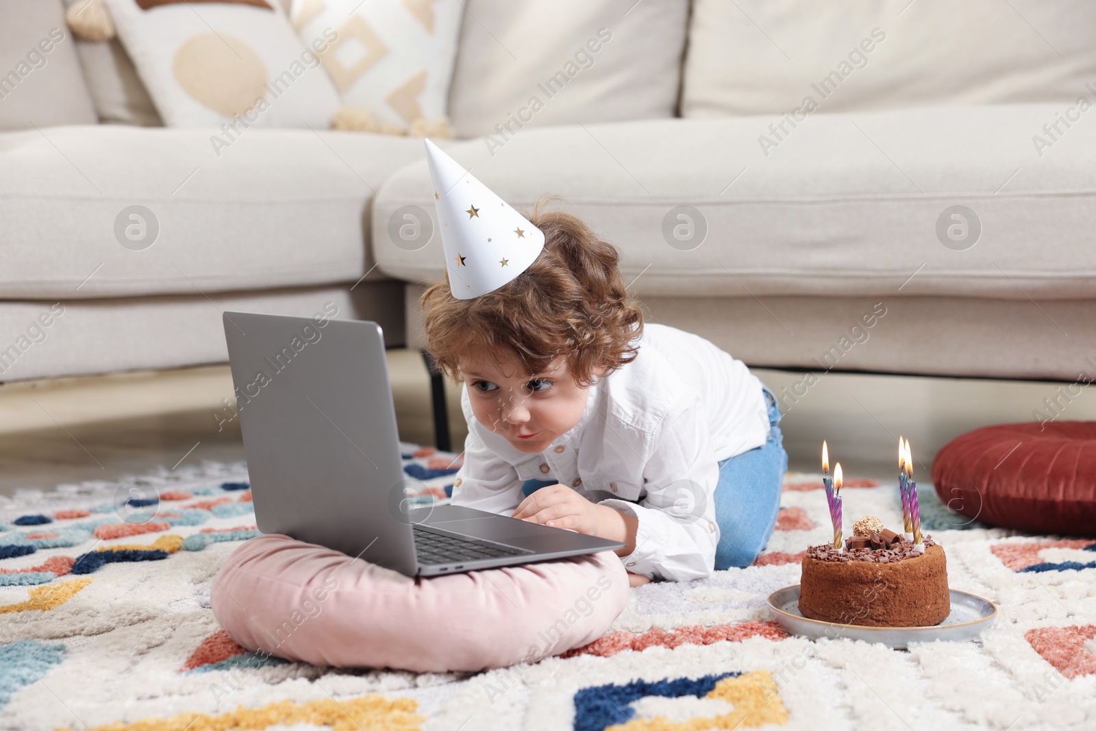 Birthday celebration. Little boy with cake having video call via laptop at home Photo of Birthday celebration. Little boy with cake having video call via laptop at home