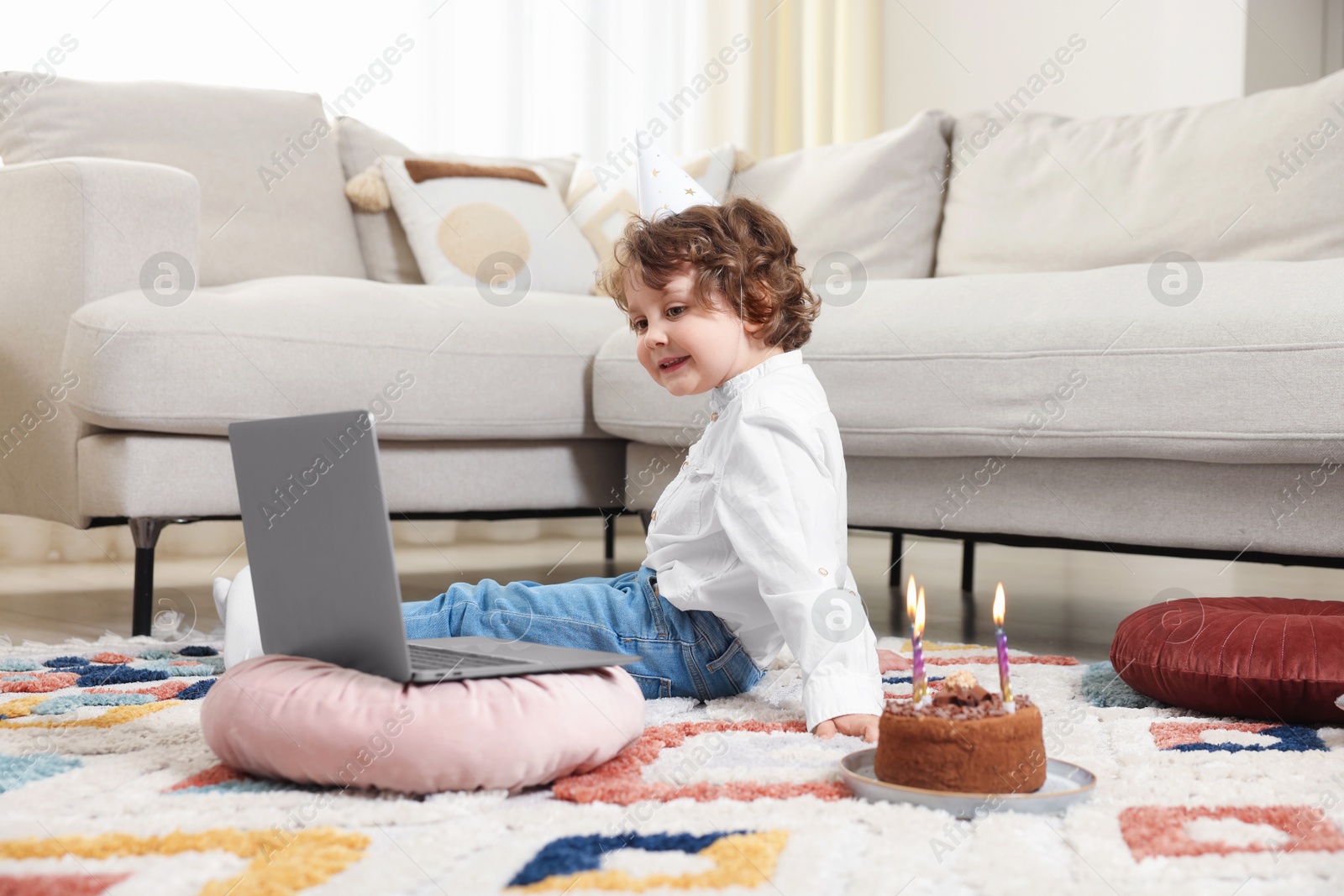 Birthday celebration. Little boy with cake having video call via laptop at home Photo of Birthday celebration. Little boy with cake having video call via laptop at home