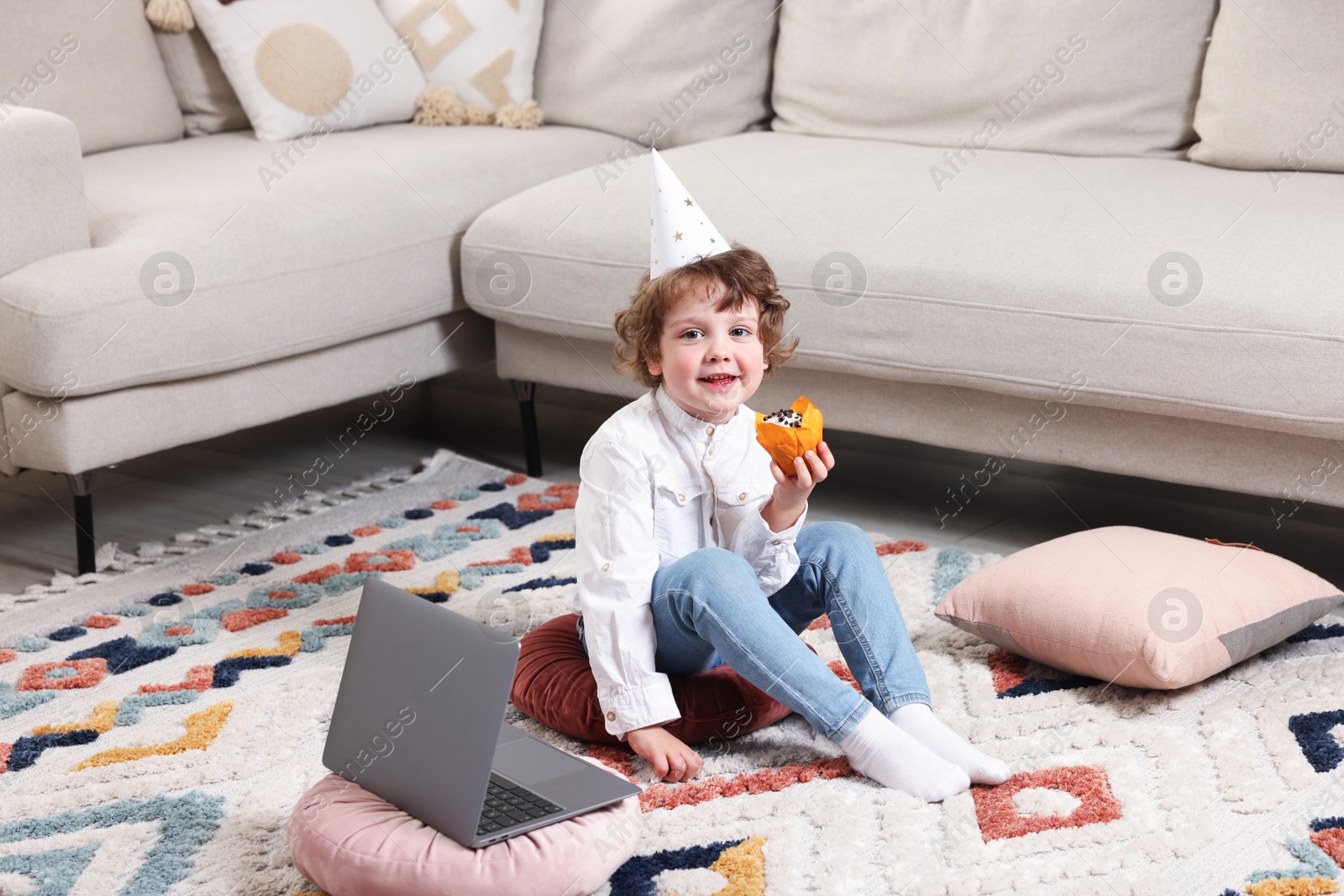 Birthday celebration. Little boy with cupcake having video call via laptop at home Photo of Birthday celebration. Little boy with cupcake having video call via laptop at home