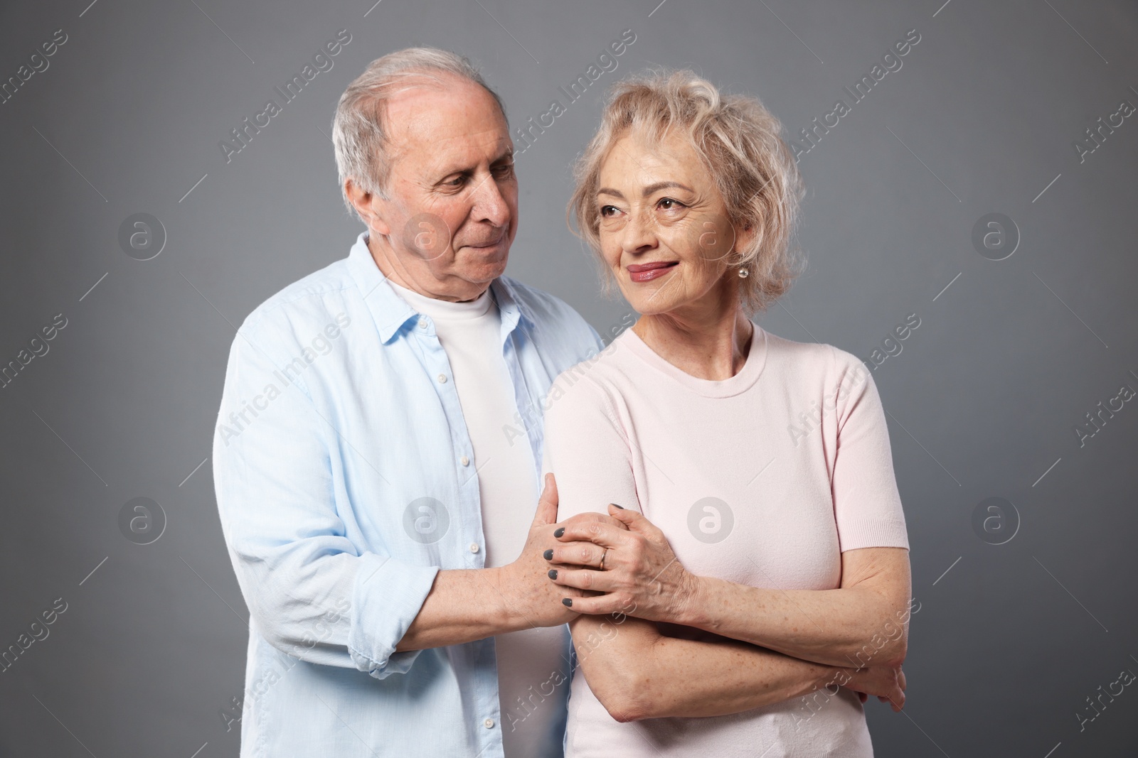 Portrait of lovely senior couple on grey background Photo of Portrait of lovely senior couple on grey background