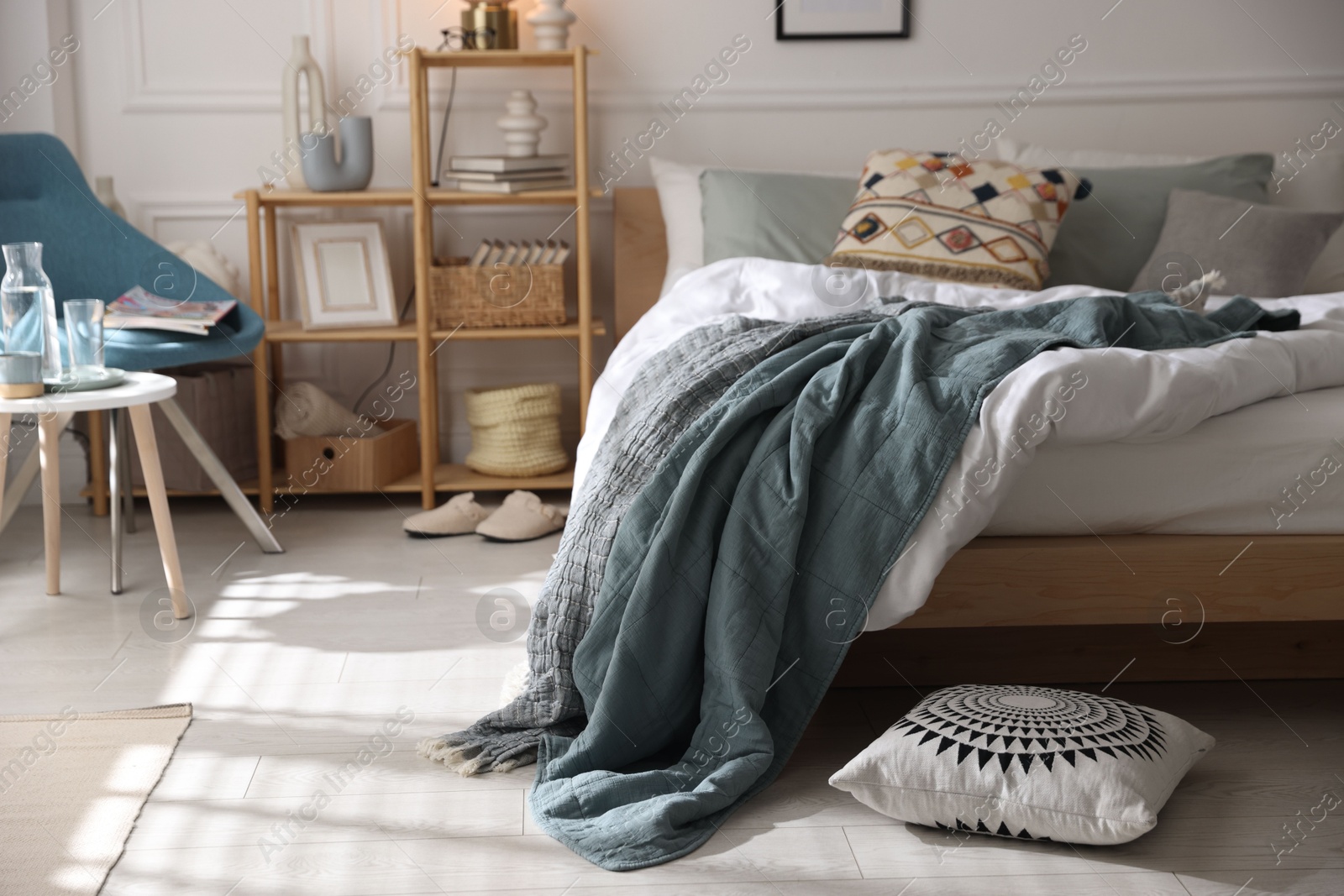 Cozy bed with soft linens, furniture and decor in stylish room. Home textile Photo of Cozy bed with soft linens, furniture and decor in stylish room. Home textile
