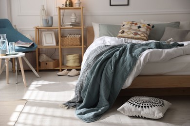 Photo of Cozy bed with soft linens, furniture and decor in stylish room. Home textile