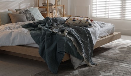 Photo of Large bed with soft linens in stylish room. Home textile