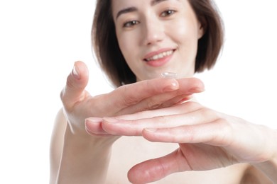 Photo of Woman with contact lens on white background, selective focus