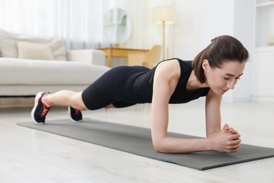 Photo of Woman doing plank exercise at home. Sport and healthy lifestyle