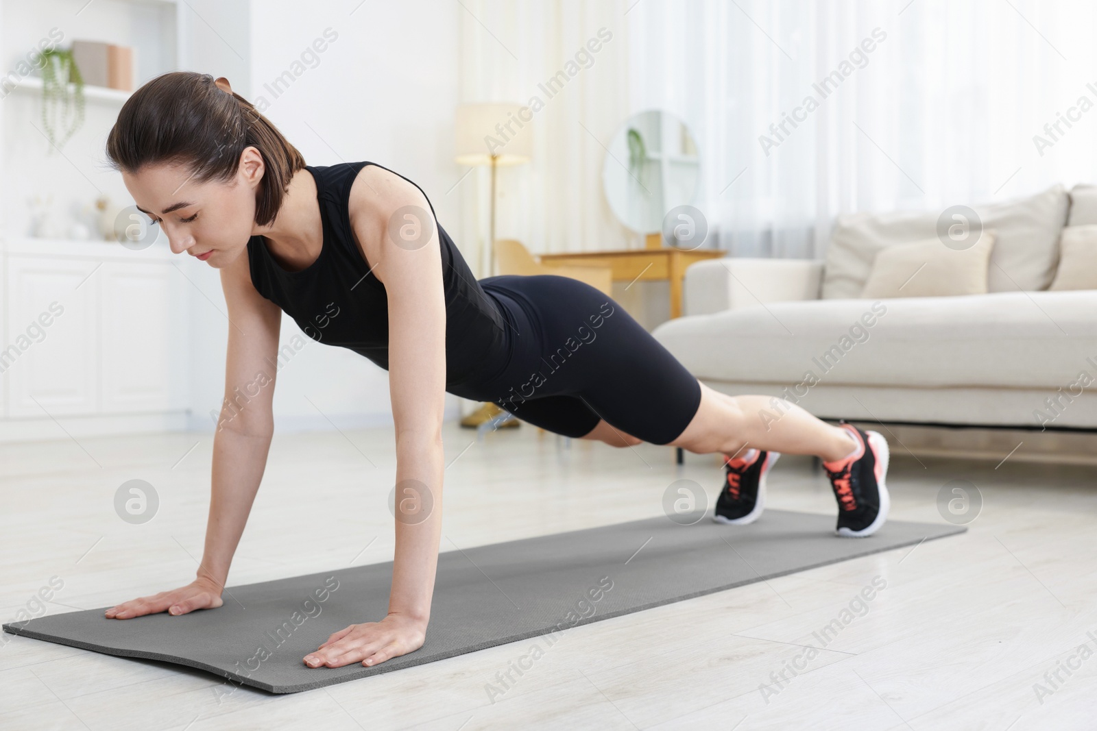 Woman doing plank exercise at home. Sport and healthy lifestyle Photo of Woman doing plank exercise at home. Sport and healthy lifestyle