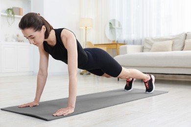 Photo of Woman doing plank exercise at home. Sport and healthy lifestyle
