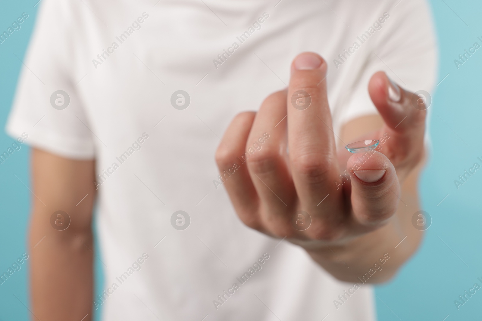 Man with contact lens on light blue background, closeup Photo of Man with contact lens on light blue background, closeup
