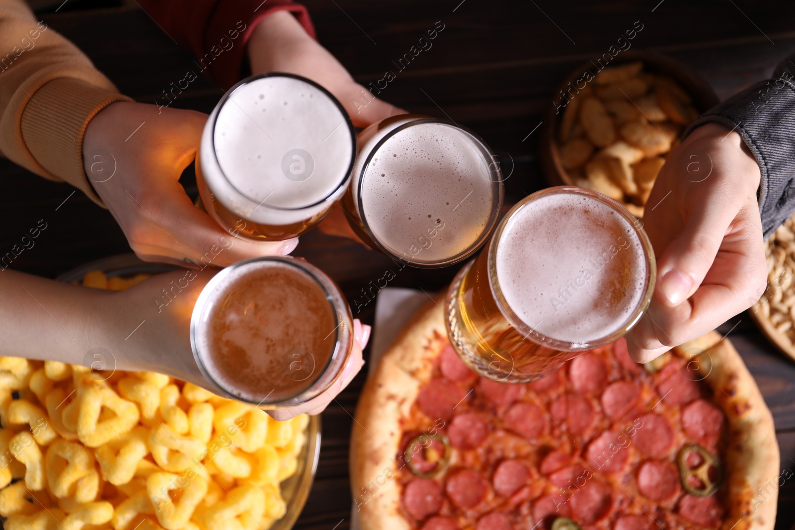 Friends with beer and snacks at wooden table, top view Photo of Friends with beer and snacks at wooden table, top view