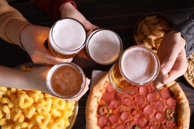 Photo of Friends with beer and snacks at wooden table, top view