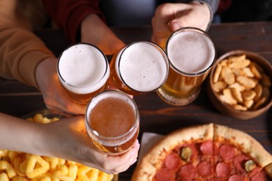 Photo of Friends with beer and snacks at wooden table, top view