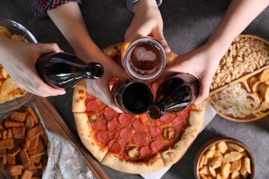 Photo of Friends with beer and snacks at grey table, top view