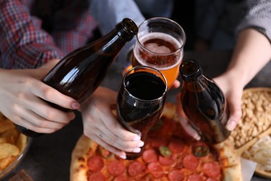 Photo of Friends with beer and snacks at grey table, closeup