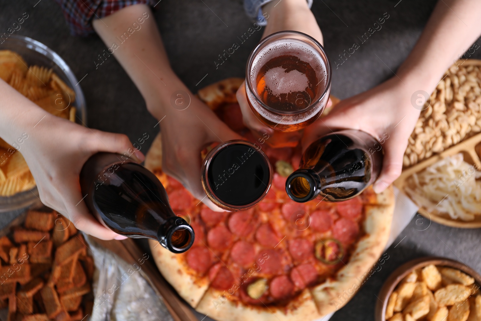 Friends with beer and snacks at grey table, top view Photo of Friends with beer and snacks at grey table, top view