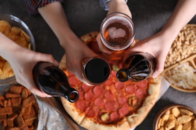 Photo of Friends with beer and snacks at grey table, top view