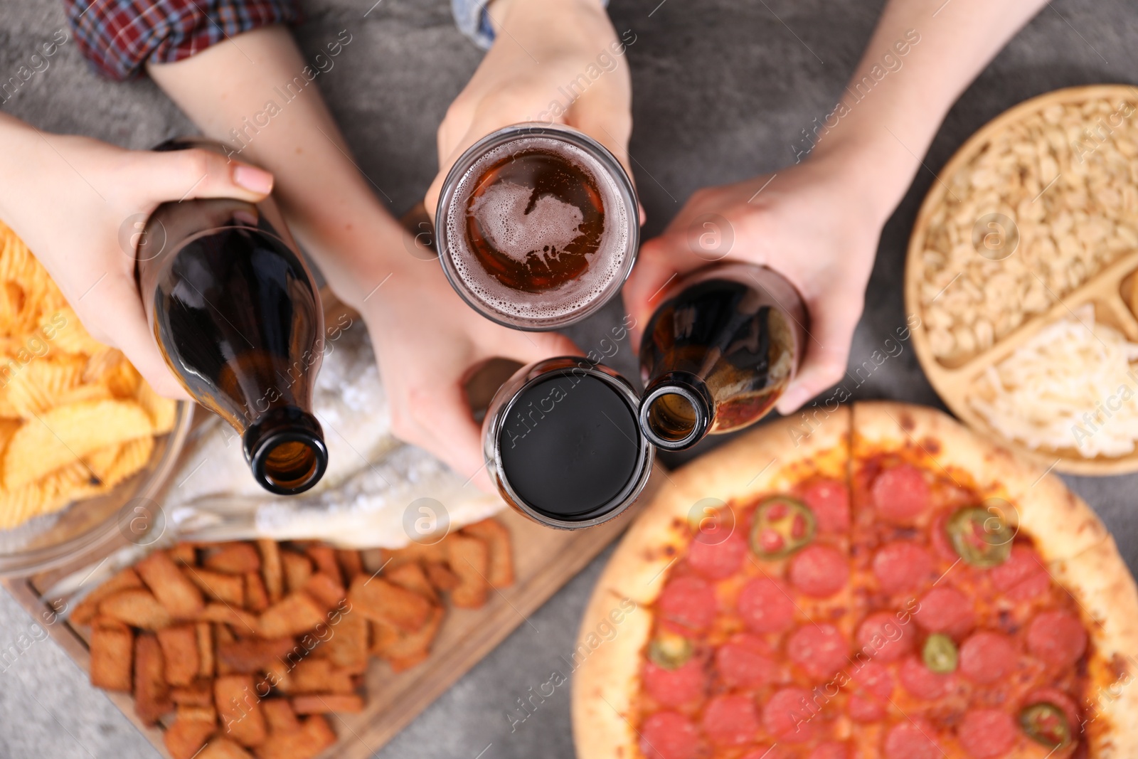 Friends with beer and snacks at grey table, top view Photo of Friends with beer and snacks at grey table, top view
