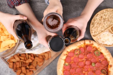 Photo of Friends with beer and snacks at grey table, top view