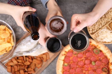 Photo of Friends with beer and snacks at grey table, top view