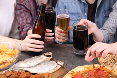 Photo of Friends with beer and snacks at grey table, closeup