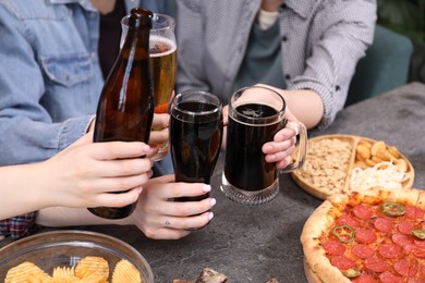 Photo of Friends with beer and snacks at grey table, closeup