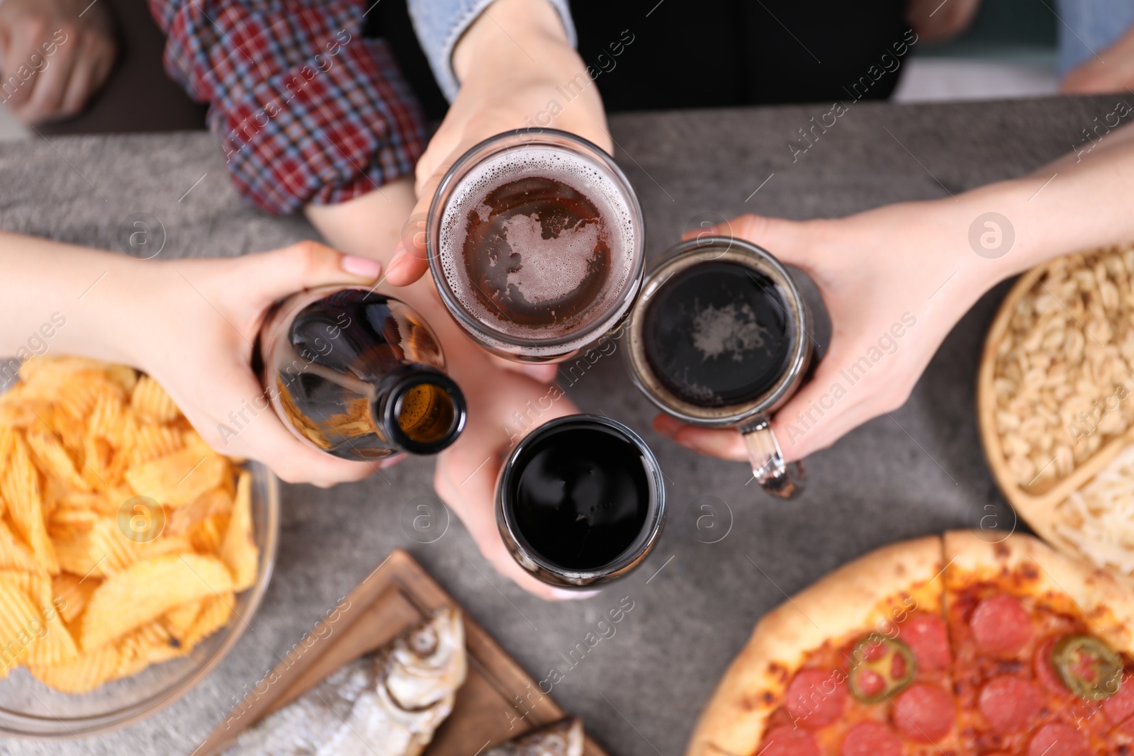 Friends with beer and snacks at grey table, top view Photo of Friends with beer and snacks at grey table, top view