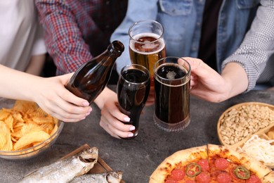 Photo of Friends with beer and snacks at grey table, closeup