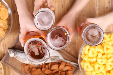 Photo of Friends with beer and snacks at wooden table, top view